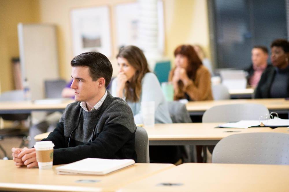 Student sitting in class intently listening to the professor.